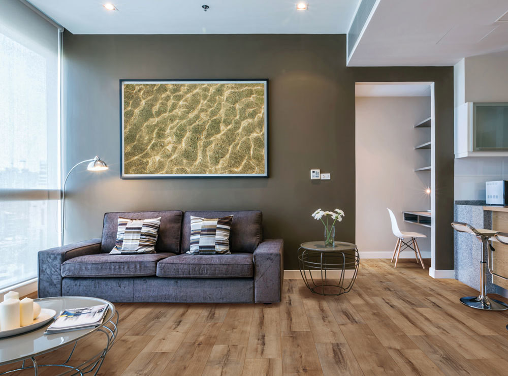 COREtec luxury vinyl flooring in a living room with a modern gray sofa and a large art piece