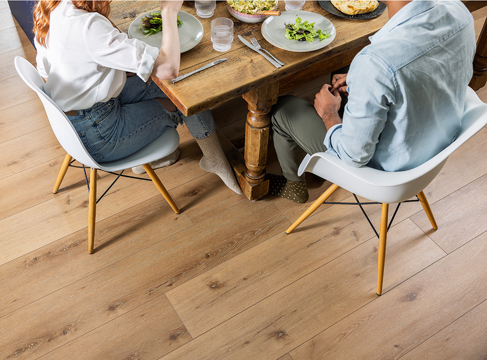 overhead shot of a couple sitting at a table, angled to show the Coretech vinyl floor