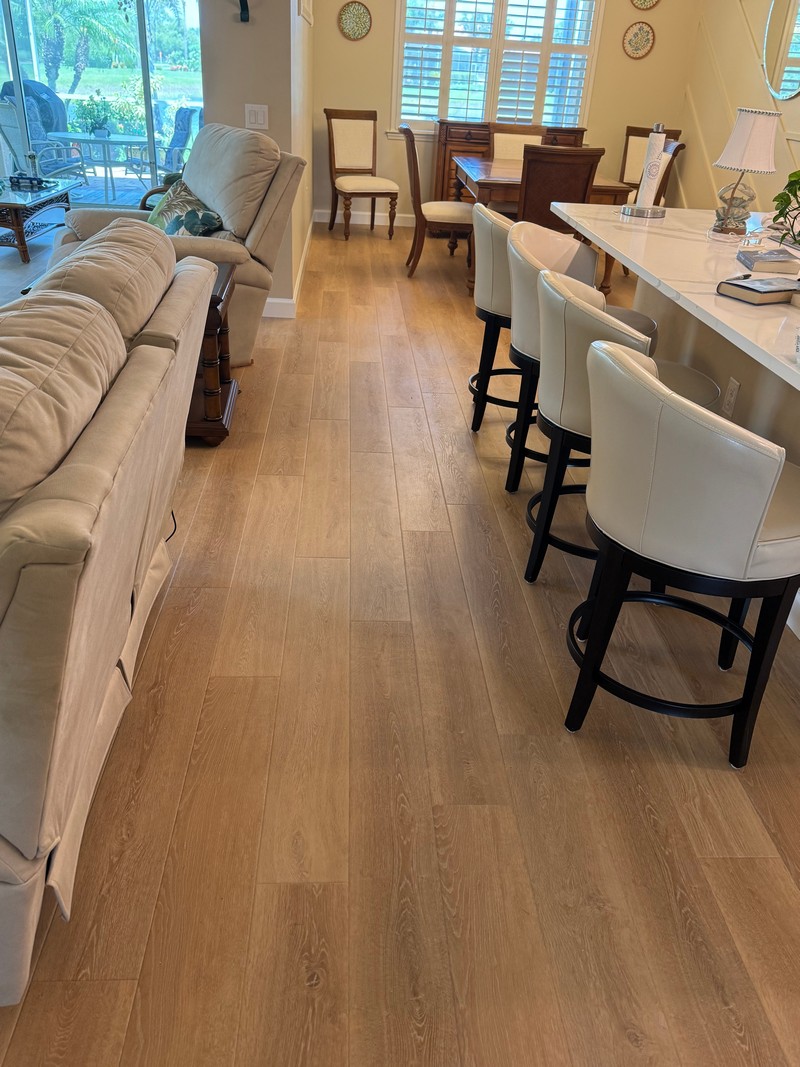 Wheat Oak COREtec Luxury Vinyl flooring between a sofa and kitchen bar
